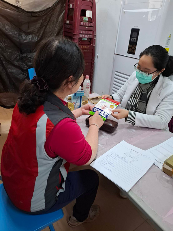 北醫114醫療服務隊義診現場,醫師向居民介紹正光金絲膏產品與使用方式。