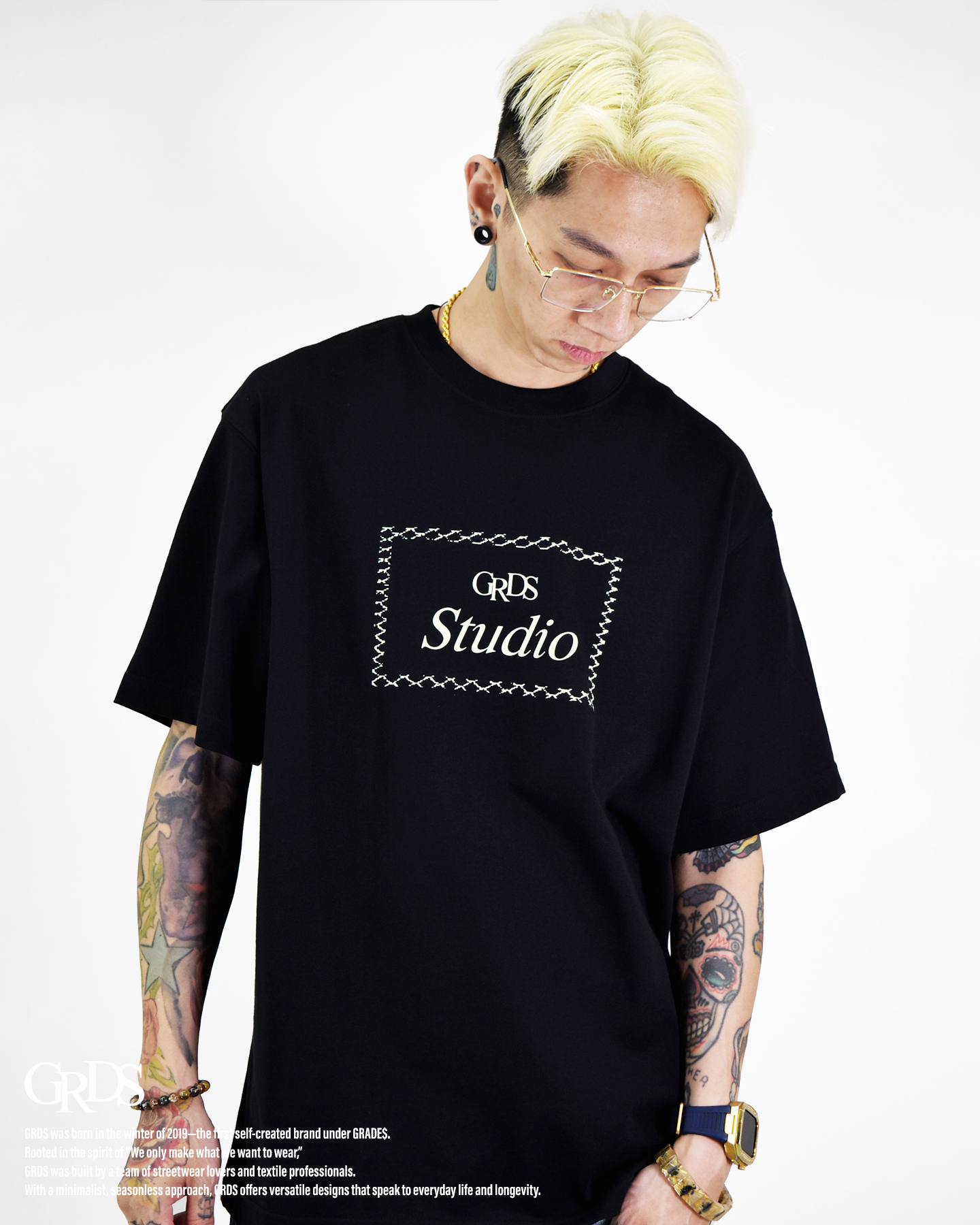 以「Barbed Frame」為設計核心，靈感取自鐵絲網與邊界的象徵語彙。 方框結構以線條勾勒出張力，呈現約束與自由之間的張弛平衡。 極簡正面搭配強勢背圖，打造出冷靜卻具侵略性的街頭印象。 厚磅棉料結