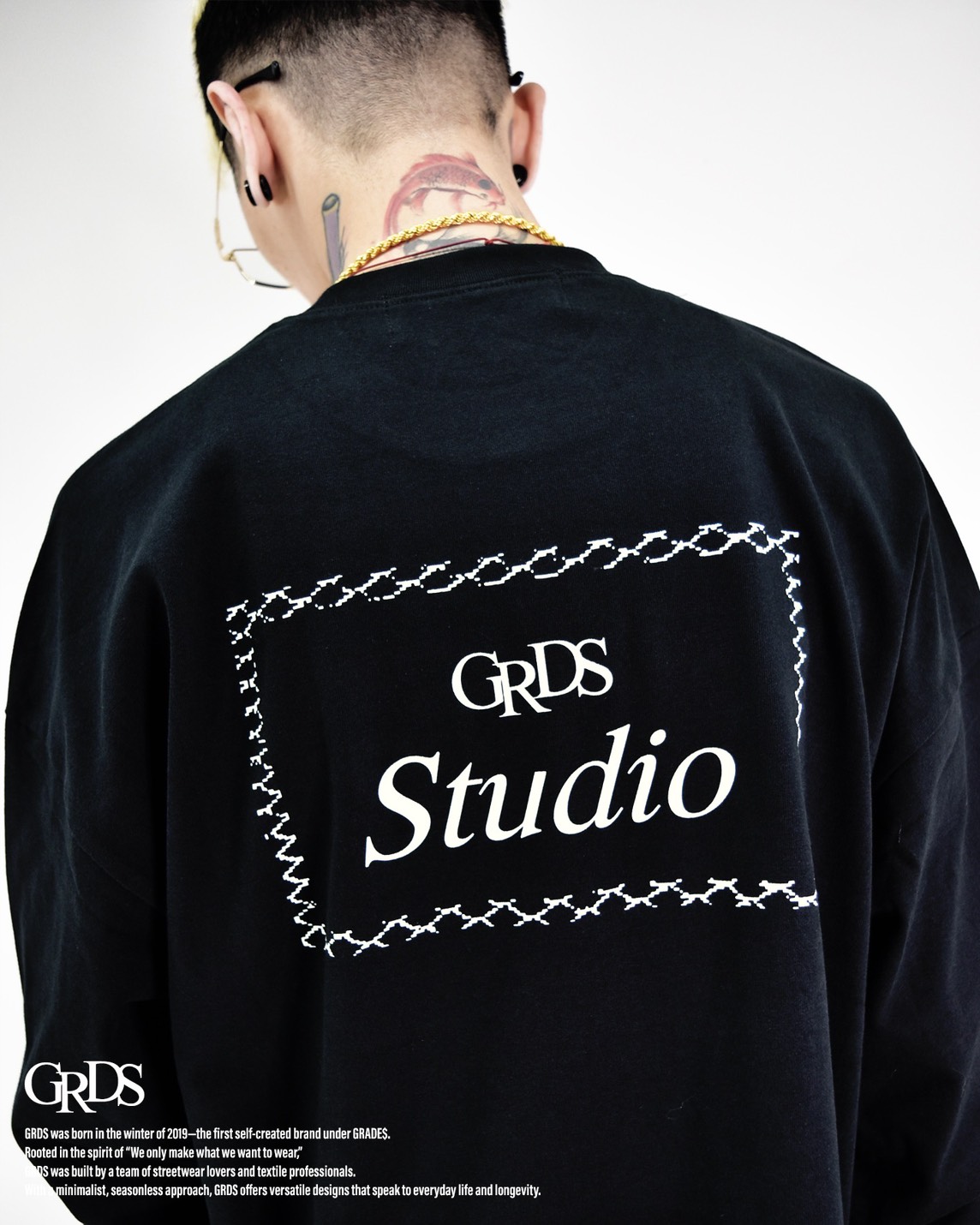 以「Barbed Frame」為設計核心，靈感取自鐵絲網與邊界的象徵語彙。 背面方框結構以線條勾勒出張力，呈現約束與自由之間的張弛平衡。 極簡正面搭配強勢背圖，打造出冷靜卻具侵略性的街頭印象。 厚磅棉