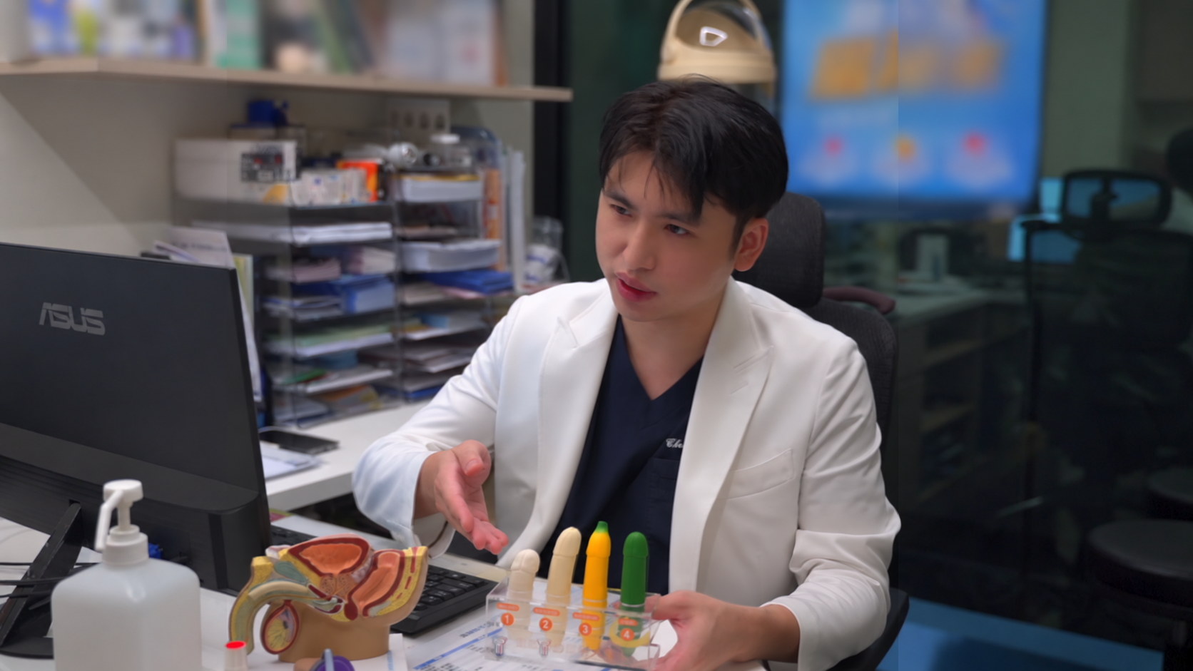 昭安泌尿科診間一角:陳昭安醫師以攝護腺解剖模型與衛教分級教具,向就診者說明檢查與處置選項,桌面另有衛教單張。