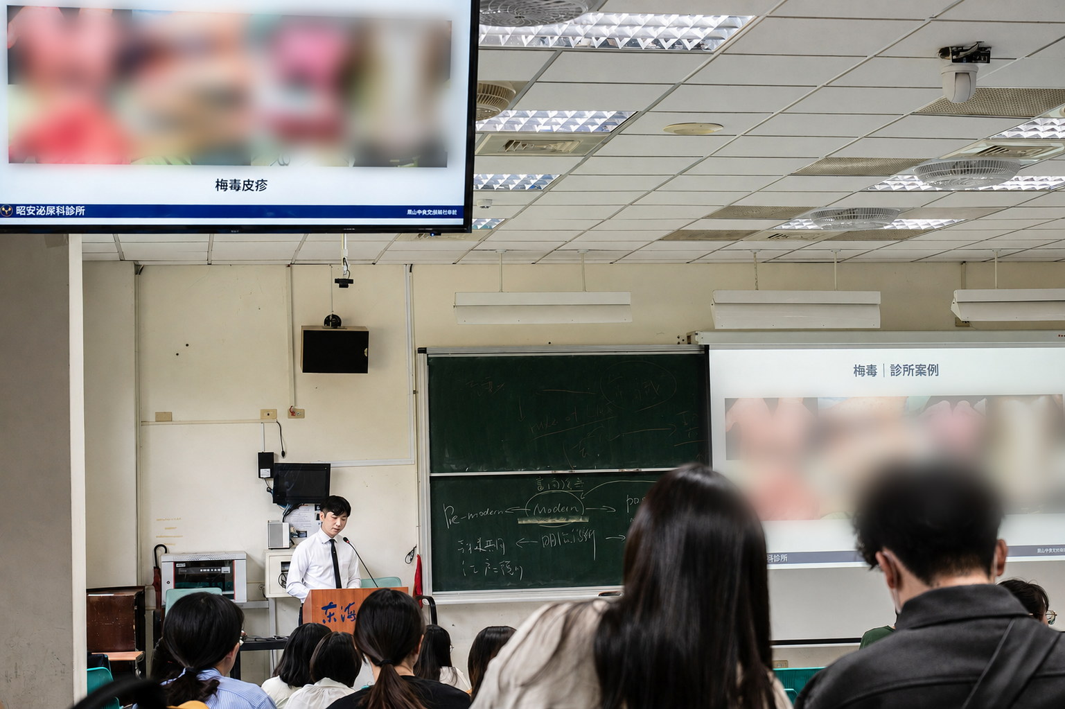 陳昭安醫師受邀至東海大學授課,在階梯教室講授梅毒主題;投影片標題為「梅毒皮疹」與「梅毒|診所案例」,投影片中的臨床影像已去識別化處理。